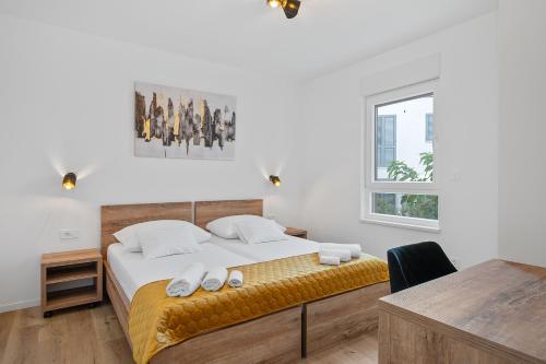 a bedroom with a bed and a desk and a window at Frida in Vodice