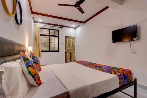 a bedroom with a bed and a flat screen tv at FabHotel Zelosena in Vagator