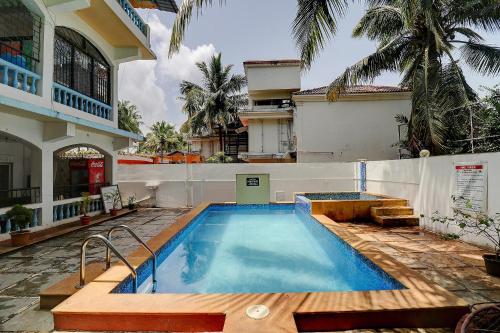 a swimming pool in front of a house at FabHotel Zelosena in Vagator