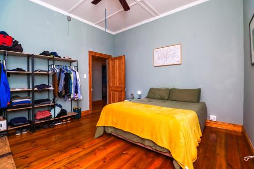 a bedroom with a bed with a yellow blanket on it at 7 on Rawson in Knysna