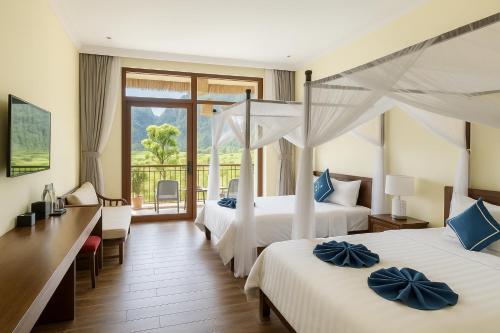 a hotel room with two beds and a balcony at Tam Coc Horizon Retreat in Vũ Lâm