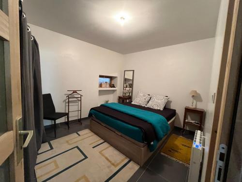 a bedroom with a bed and a chair in it at La Ruelle in Die