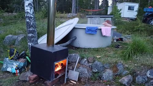 una vasca da bagno posizionata accanto a una stufa di 2 small cabins beach, boat, fishing, kayaks sauna a Spersboda