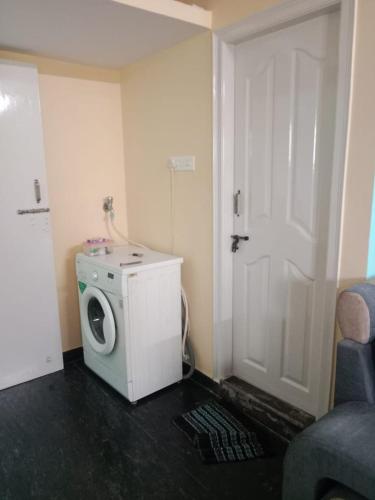 a washer and dryer in a room with a door at Single Bedroom Full independent house walkable distance to Dasarahalli Metro in Bengaluru