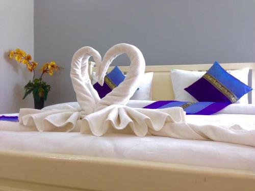 two white swansrendered to look like they are kissing on a bed at Ananya Residence Amata City Hotel in Chon Buri