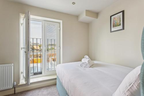 a bedroom with a white bed and a window at Charming Windsor Cottage, Castle Views, Garden & Walk Everywhere in Windsor