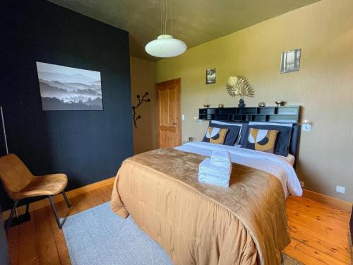 a bedroom with a large bed and a chair at Le Manoir W in Waimes