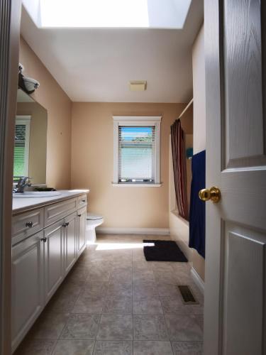 a bathroom with a sink and a toilet and a window at Eagle's House, Room #2 in Victoria
