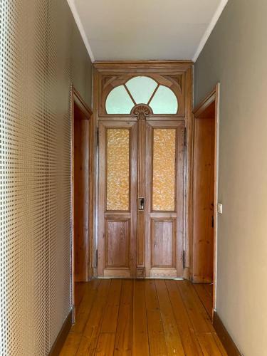 an empty room with a wooden door and a window at Le Manoir W in Waimes
