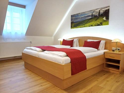a bedroom with a large wooden bed with red pillows at Gästehaus Ferk - Frühstückspension, Bed & Breakfast in Bad Radkersburg