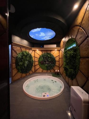 a bathroom with a tub in a room with plants at Soko IN Spa in Soko Banja