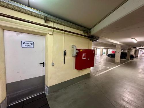 an empty parking garage with a parking garage sign on the wall at Hotel Landhaus Milser in Duisburg