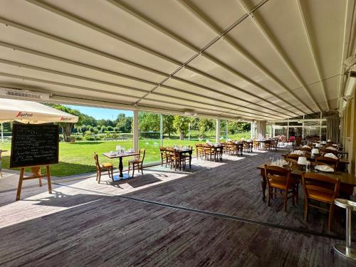 a restaurant with tables and chairs and a large marquee at Hotel Landhaus Milser in Duisburg