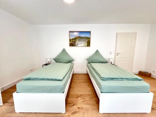 two beds in a room with white walls at Privatzimmer in Apartment Brunnenstraße Braubach in Braubach