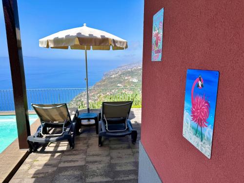 a patio with chairs and an umbrella and the ocean at Sunset Dreams - Arco da Calheta in Arco da Calheta