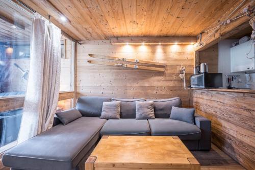 a living room with a couch and a table at APT centre station vue sur les pistes de Val Thorens 6p in Val Thorens