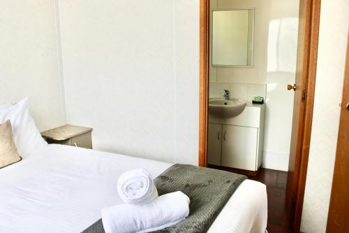 a hotel room with a bed with towels on it at BIG4 Rutherglen Holiday Park in Rutherglen
