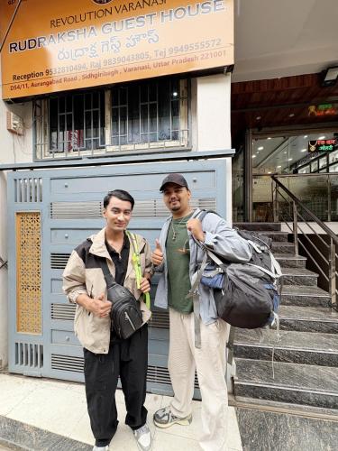 two men are standing in front of a building at Rudraksha Guest House in Varanasi