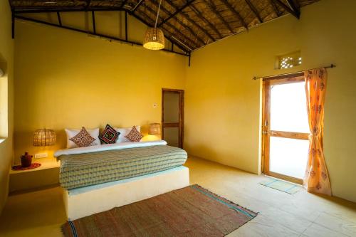 a bedroom with a bed in a yellow wall at Vijay Bagh in Jaisalmer