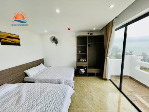 two beds in a room with a window at Sunrise Hotel Thiên Cầm in Ha Tinh