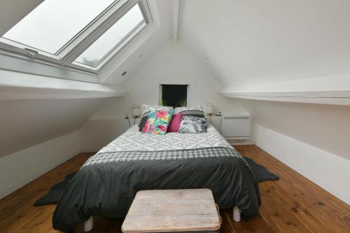 a bedroom with a bed and a skylight at La Maisonnette - Maison atypique à la campagne 