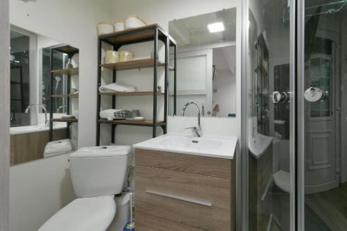 a bathroom with a toilet and a sink and a shower at La Maisonnette - Maison atypique à la campagne 