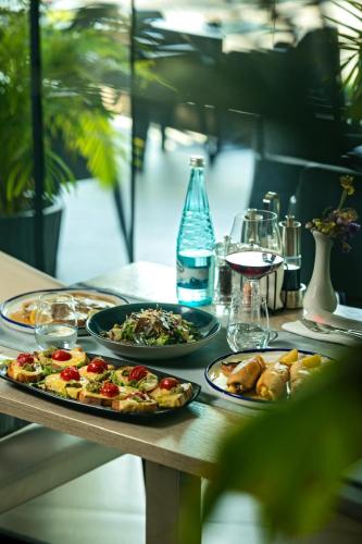 a table with two plates of food and a bottle of water at Albes Hotel in Fier