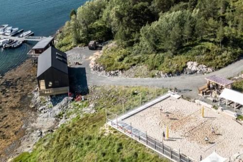 an aerial view of a building on a beach next to the water at Sjåen på Balsnes Gård in Hitra