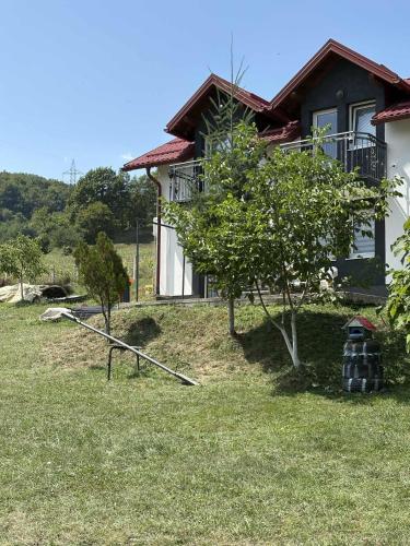 a house with a tree in front of it at Holiday & Living House Near Sarajevo in Vogošća