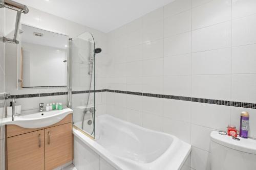 a white bathroom with a tub and a sink at Giorgio Downtown 2 Bedroom Apartment in Larnaka