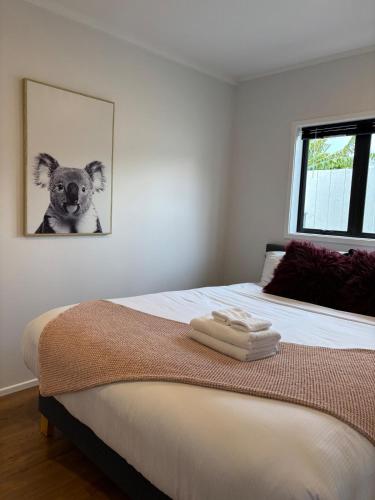 a bedroom with a bed with a dog picture on the wall at Convenient Retreat in Onehunga in Auckland