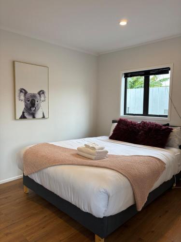 a bedroom with a large bed with a picture of a dog at Convenient Retreat in Onehunga in Auckland