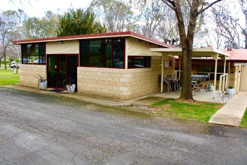 a small house with a tree next to a street at BIG4 Rutherglen Holiday Park in Rutherglen