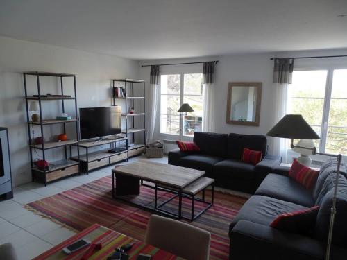 a living room with a couch and a table at Maison confortable à La Garde-Freinet, 160 m², vue ville in La Garde-Freinet