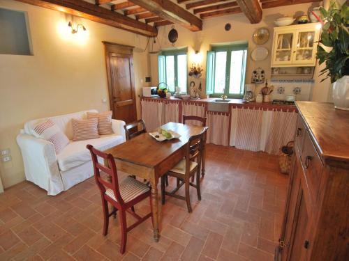 a kitchen and living room with a table and a couch at Cottage in Val di Chiana in Castiglion Fiorentino