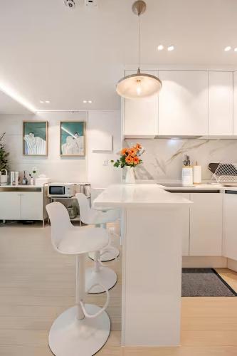 a white kitchen with a white table and chairs at HausKomma 서울 홍대,이태원,명동 짐보관 무료 주차 엘레베이터 새아파트 in Seoul