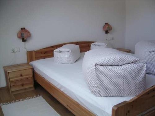 ein Schlafzimmer mit einem Holzbett mit zwei Kissen in der Unterkunft Haus Dreiländerblick in Sulzberg