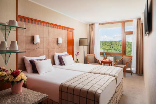 a hotel room with a large bed and a window at Silvanus Hotel in Visegrád