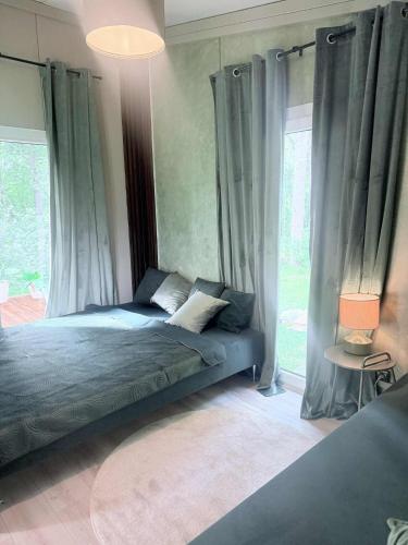 a bedroom with a bed with curtains and a window at Forest Resort House in Pašiliai