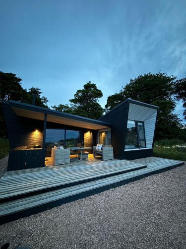 a modern house with a large deck with a table at Off Grid Travel at Cambo Estate in St. Andrews
