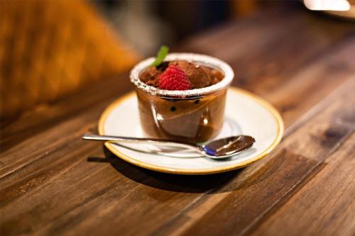 a cup of coffee on a plate with a strawberry in it at Radisson Blu Hotel, Hamburg in Hamburg