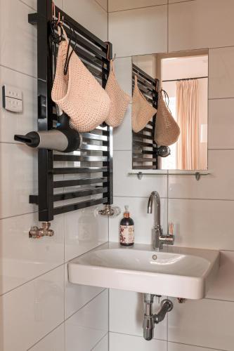 a white bathroom with a sink and a mirror at Mille Fleur Apartments in Voeren