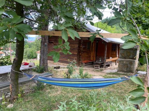 a blue hammock in front of a log cabin at Piramida Mjeseca in Visoko