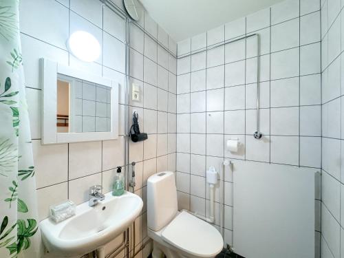 a bathroom with a toilet and a sink and a shower at Cozy city suites in Rovaniemi