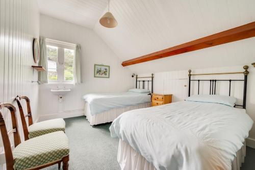 Un dormitorio con dos camas y una silla y una ventana. en Umballa, en Herne Bay