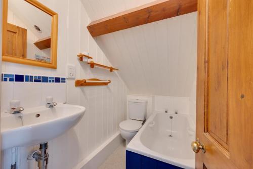 Un baño blanco con lavabo e inodoro. en Umballa, en Herne Bay