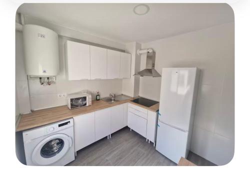Una cocina con un frigorífico blanco y una lavadora. en Habitación BNB cama doble, en Albacete