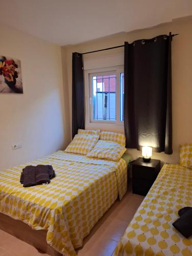Un dormitorio con dos camas y una ventana. en Casa Zahraa, en Mazarrón