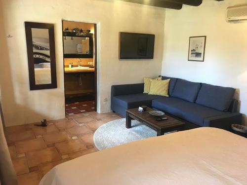 a living room with a blue couch and a table at Finca Toni in Sant Josep