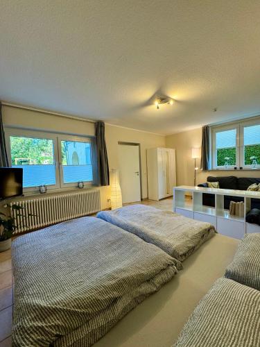 a bedroom with a large bed and two windows at Haases Ferienwohnung in Remscheid
